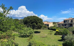 A residential area with houses, a large tree, and a grassy field. - Charming studio with terrace near the beaches (Hyères)