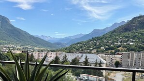 Paisaje montañoso con edificios residenciales y cielo despejado.