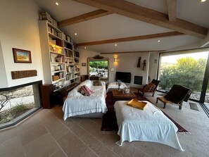 A spacious room with two beds, a fireplace, a bookshelf, and a large window offering a view of the outdoors. - Villa with pool and panoramic views in Ollioules (Ollioules)