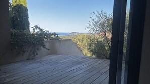 Een kamer met uitzicht op een houten terras en balkon.