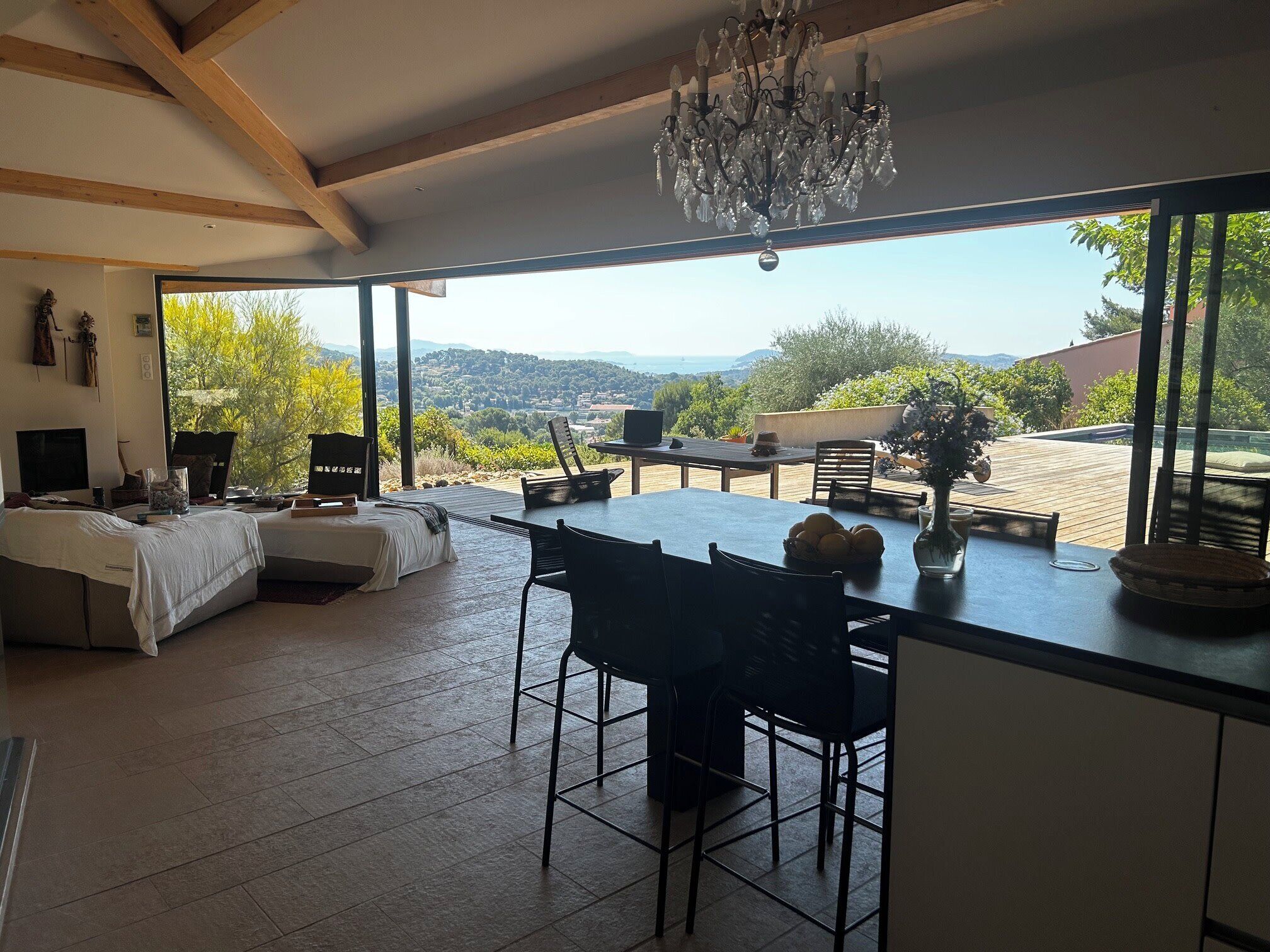 A modern kitchen with a large island, dining area, and a view of the countryside.