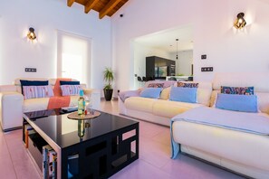A modern living room with a sofa, a coffee table, and a dining area. - Villa Pareteta - Three Bedroom Villa, Sleeps 6 (Binissalem)