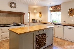 A kitchen with a wooden countertop, a built-in wine rack, and a microwave.
