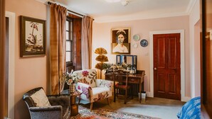 A room with a chair, a table, a mirror, a door, and a framed picture on the wall. - Skylarke - Five Bedroom Castle, Sleeps 10 (Portpatrick)