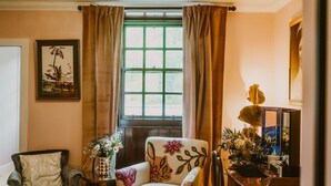 A room with a window, a chair, a table, and a vase with flowers. - Skylarke - Five Bedroom Castle, Sleeps 10 (Portpatrick)