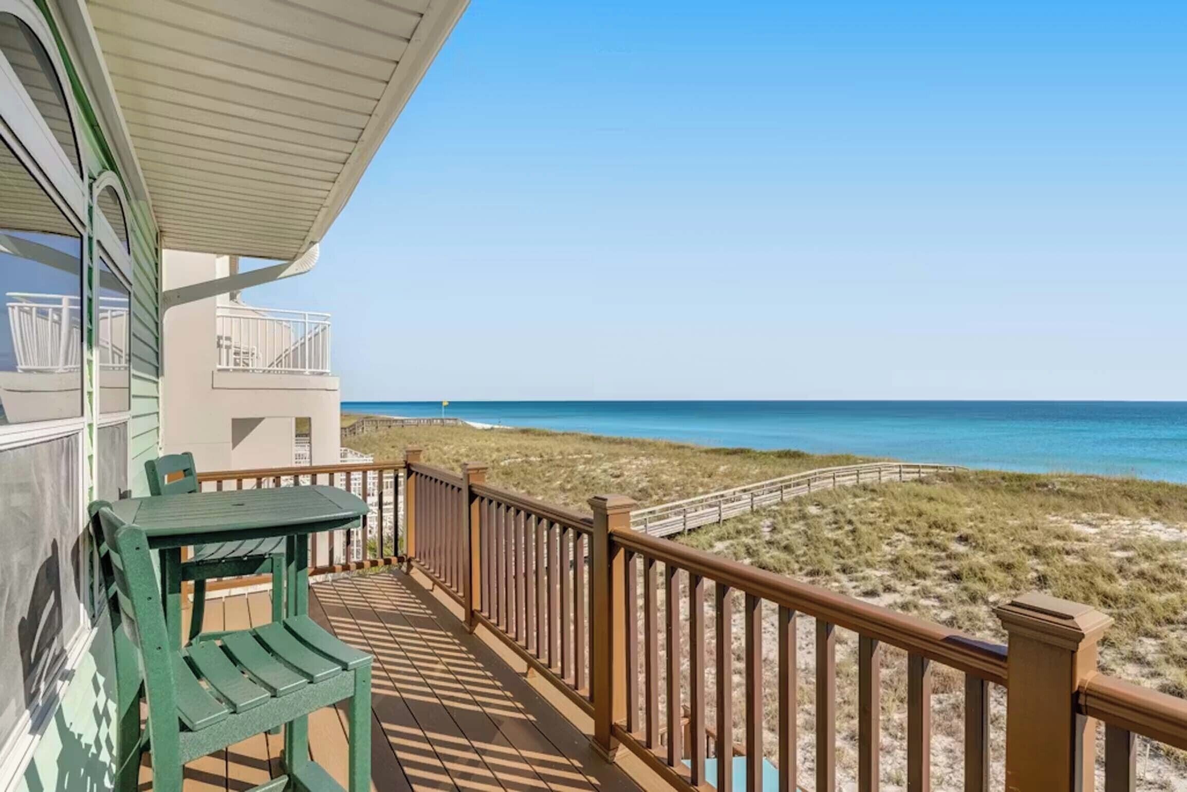 Een balkon met uitzicht op het strand en de oceaan.