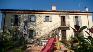 A building with a red slide, a staircase, and a balcony. - GuestHost - Lisignano Cozy Apartment with Parking (Gazzola)