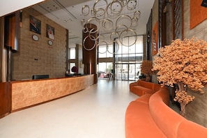 A hotel lobby with a reception desk, seating area, and decorative elements. - Qira Hotel (Makkah)