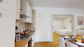 Eine moderne Küche mit Gasherd, Spüle und Essbereich, gedeckt für das Frühstück.
