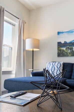 A room with a bed, a lamp, a star-shaped object on a table, and a remote control.