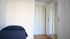 A bedroom with a bed, a wardrobe, and a mirror. - SE295 - Senigallia, spacious three-room apartment with parking space and garden. (Senigallia)