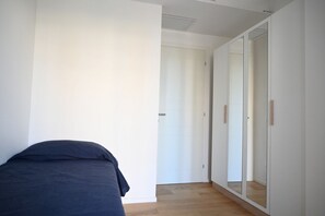 A bedroom with a bed, a wardrobe, and a mirror. - SE295 - Senigallia, spacious three-room apartment with parking space and garden. (Senigallia)