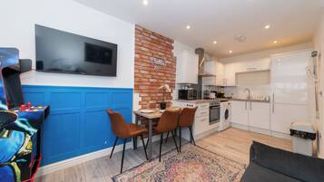 A modern kitchen with white cabinets, a built-in oven, and a microwave.