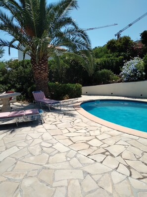 A swimming pool with a stone patio, lounge chairs, and a palm tree. - APPARTEMENT EN RDJ VUE MER AUX ISSAMBRES VAR (LES ISSAMBRES Roquebrune sur argens)