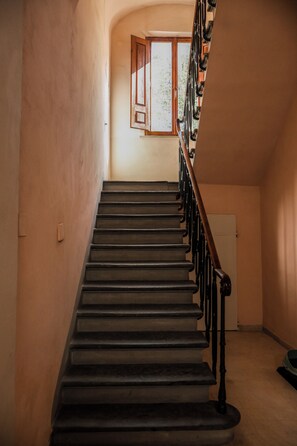 A staircase with a wooden handrail, leading to a landing with a window. - La Casa sul Corso - Nel cuore di Foiano della Chiana (Foiano della Chiana)