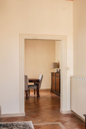 A hallway with a dining area, a cabinet, and a radiator. - La Casa sul Corso - Nel cuore di Foiano della Chiana (Foiano della Chiana)