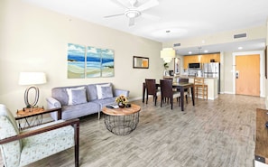 A living room with a sofa, coffee table, and artwork on the wall. - Fairway Views & Resort in Sandestin's Baytowne Wharf (Miramar Beach)