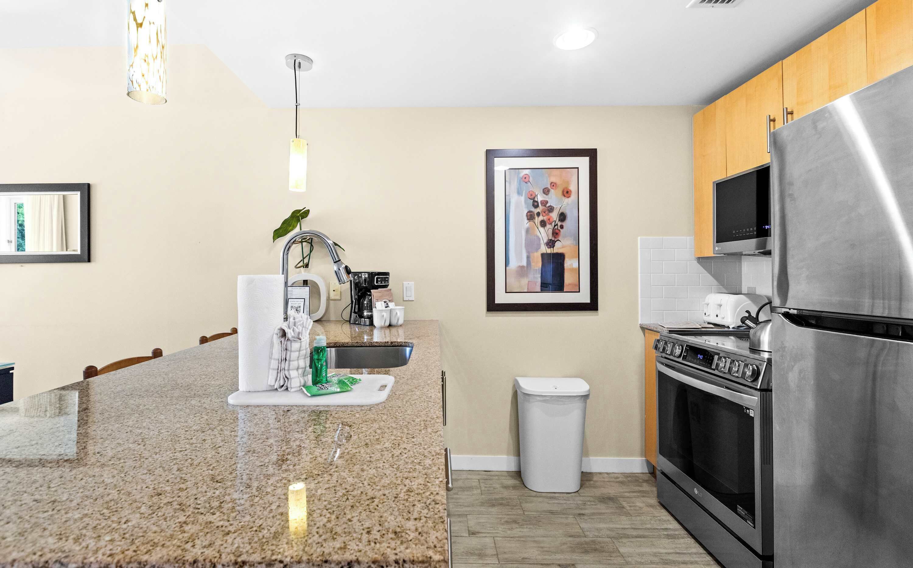 A modern kitchen with granite countertops, stainless steel appliances, and wooden cabinets.