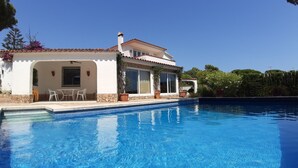 Um imóvel residencial com piscina, área de estar ao ar livre e jardim.