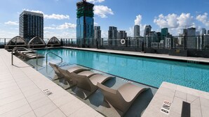 A rooftop pool with a city skyline view, a construction crane, and a sign indicating 'EXIT'. - Downtown Miami Boutique Residence with Rooftop Pool, Gym, Cowork & Den (Miami)