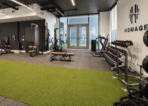 Una palestra con attrezzature per esercizi, un tappeto verde e un'ampia finestra.