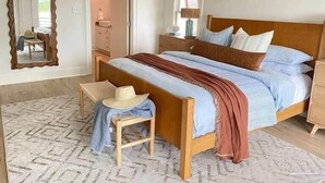 A bedroom with a wooden bed, a mirror, a chair, and a dresser. - Relaxing, water front rental in Orange Beach with pool access and boat slip. (Orange Beach)