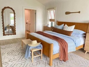 A bedroom with a wooden bed, a mirror, a chair, and a dresser. - Relaxing, water front rental in Orange Beach with pool access and boat slip. (Orange Beach)