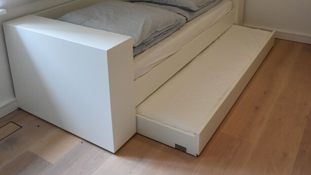 A loft-style bed with a built-in storage bench underneath, positioned in a room with wooden flooring and white walls. - Exclusive "Backbord" vacation rental with private boat access and dock (Boren)