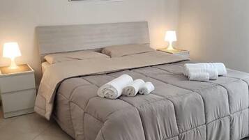 A bedroom with a bed, two bedside tables, and wall art.