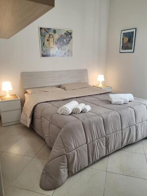 Un dormitorio con cama, dos mesitas de noche y decoración en la pared.