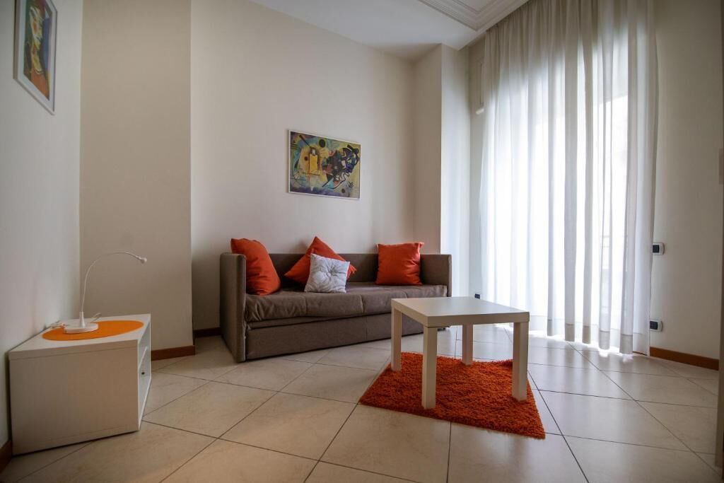 Un salon moderne avec un canapé, une table basse et une table d’appoint.