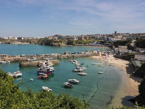 Eine Küstenstadt mit einer Marina, einem Sandstrand und Gebäuden im Hintergrund.
