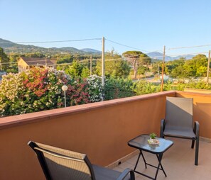 A balcony with two chairs, a small table, and a potted plant. - Da Rose Marys Vacation Home in Policastro Bussentino. In the heart of Cilento (Campania)