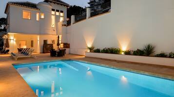 A swimming pool with a white building in the background.