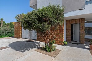 Ein modernes Haus mit Ziegelaußenwand, einer Garagentür und einem Baum im Vorgarten.