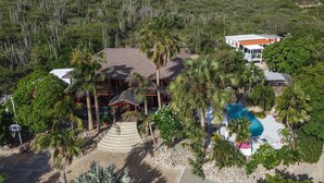 A resort with a pool, palm trees, and a mountainous backdrop. - Villa  Luna LLena located in the Jamanota hills of Aruba's Arikok National park (Santa Cruz)