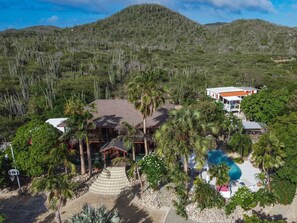 Ett semesterparadis med pool, palmer och en bergskedja i bakgrunden.