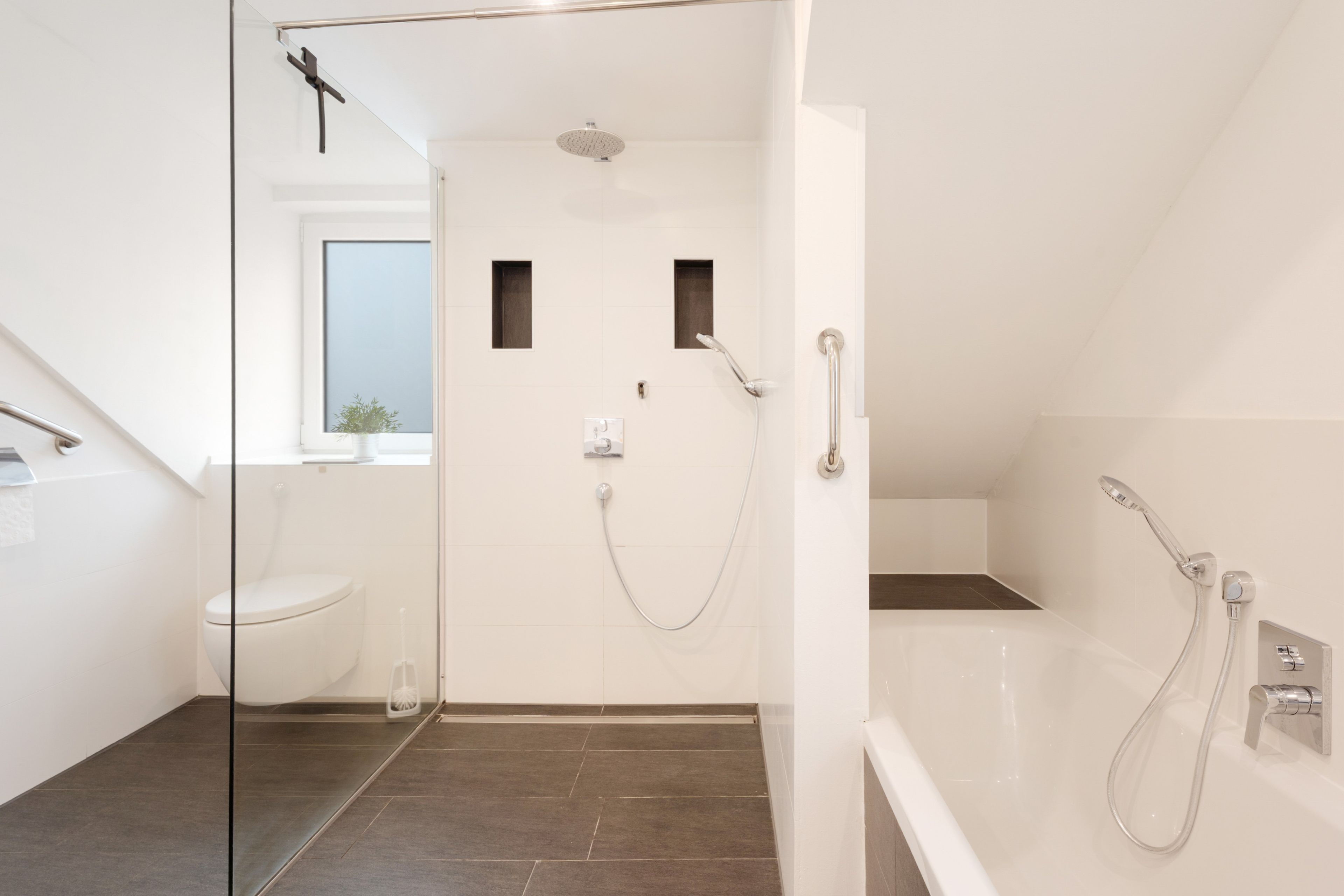 Ein modernes Badezimmer mit Duschkabine aus Glas, Toilette und Badewanne.