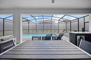 A modern outdoor pool area with a glass enclosure, lounge chairs, and a bar. - 8BR house with private pool in clermont (Clermont)