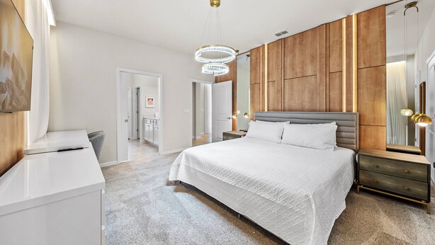 Ein modernes Schlafzimmer mit einem großen Bett, einem Nachttisch, einer Kommode und einem Spiegel.