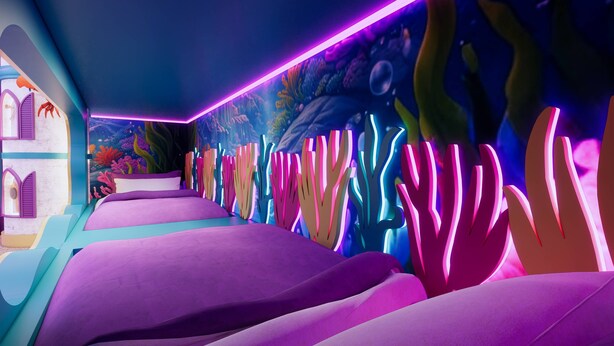 Une pièce avec un lit, une fresque murale et une bande lumineuse au néon.
