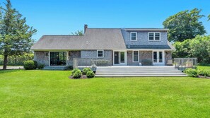 A two-story house with a front porch, a garage, and a well-maintained lawn.