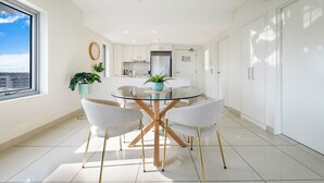 Una cucina moderna con isola centrale, mobili bianchi e un'ampia finestra.