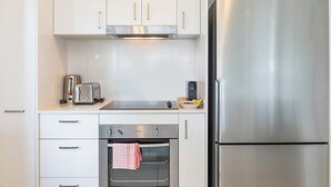 Una cucina moderna con elettrodomestici in acciaio inossidabile, tra cui frigorifero, forno e tostapane.