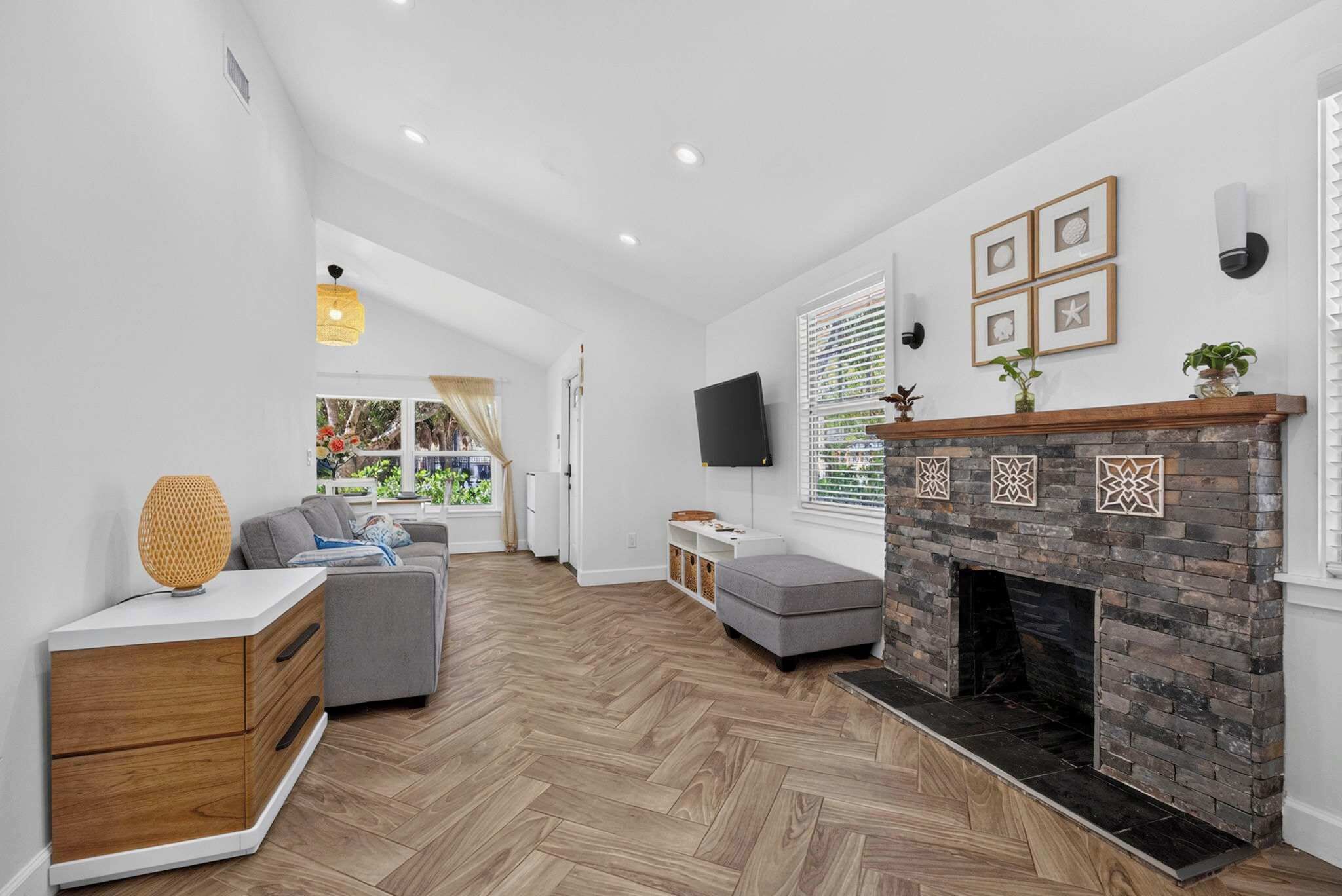 A modern living room with a fireplace, a sofa, a coffee table, and a television.