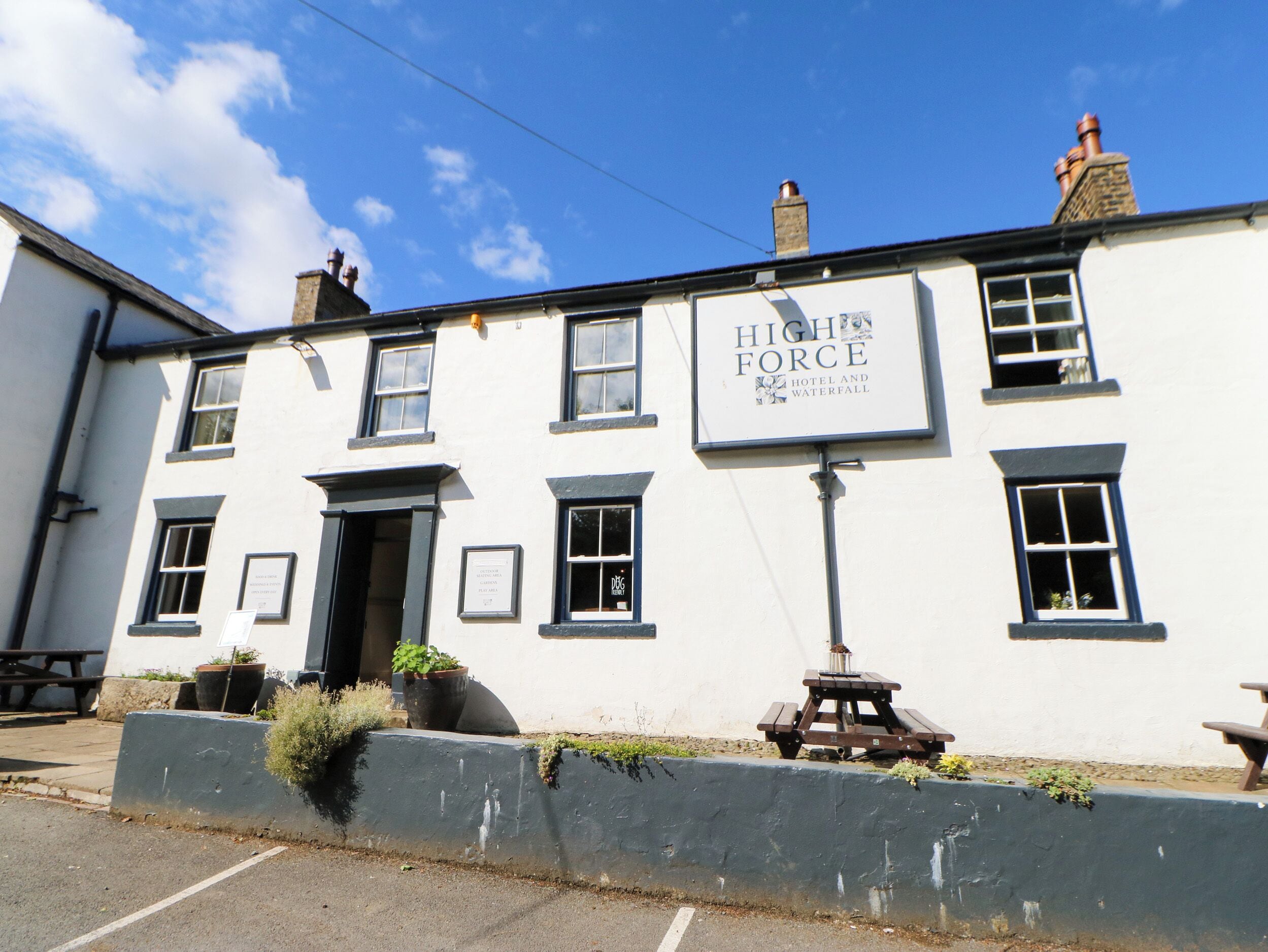 Un edificio blanco con un cartel que dice 'High Force Hotel and Waterfall'.