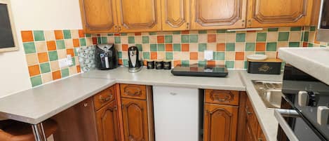 A kitchen with wooden cabinets, a coffee maker, a toaster, and a dishwasher.