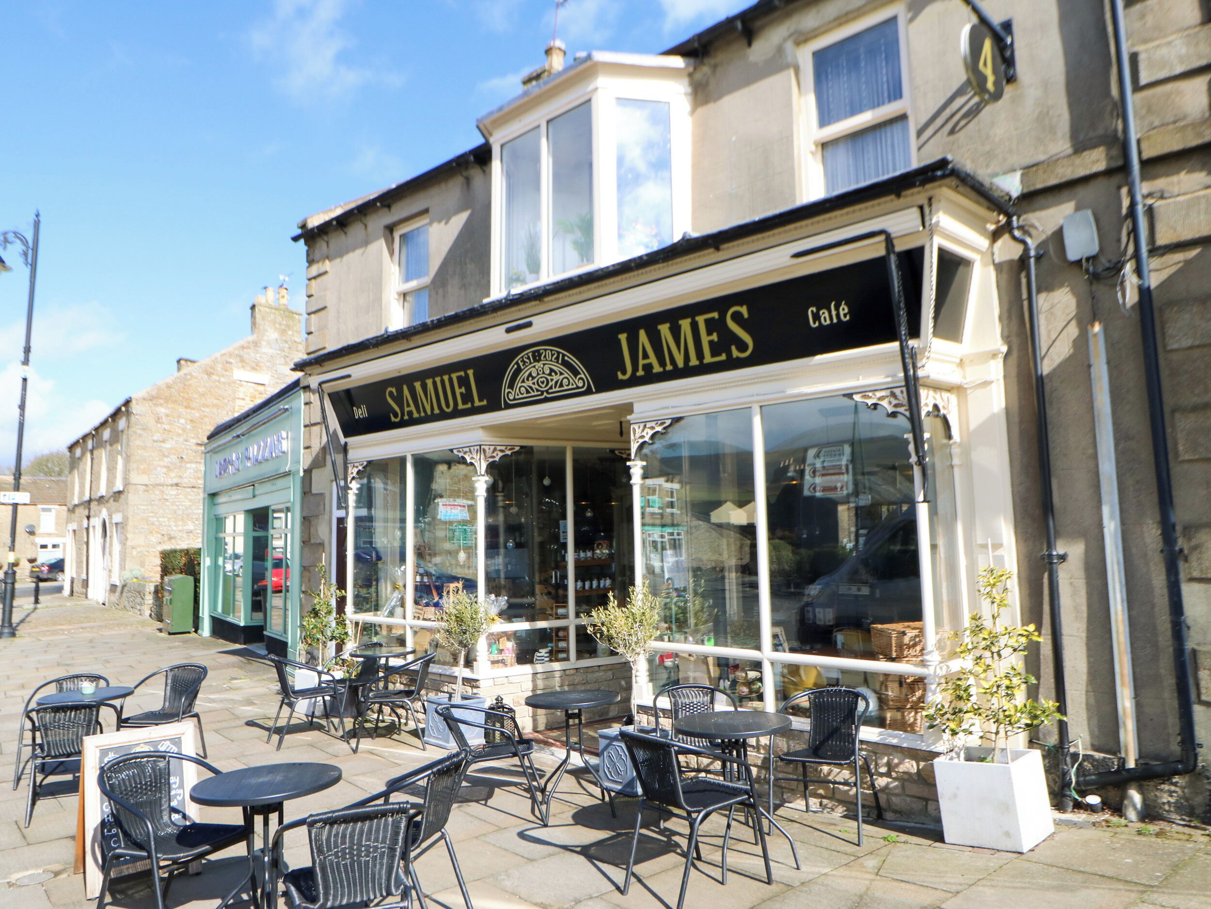 A cafe named 'SAMUEL JAMES' with outdoor seating and a clear view of the street.
