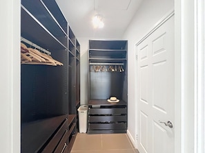 A walk-in closet with shelves, a hat rack, and a trash bin. - Villa Sunrise Indigo – Spacious Retreat with Gorgeous Sea Views (Cul-de-Sac)