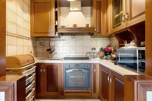 Una cocina con armarios de madera, estufa y microondas.
